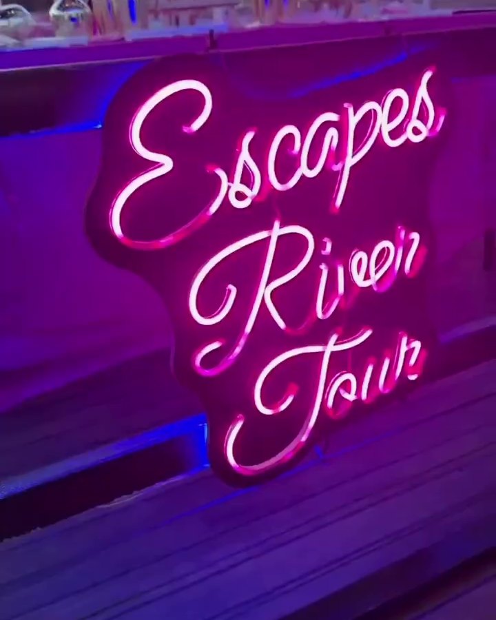 Close-up of the pink Escapes River Tour neon sign